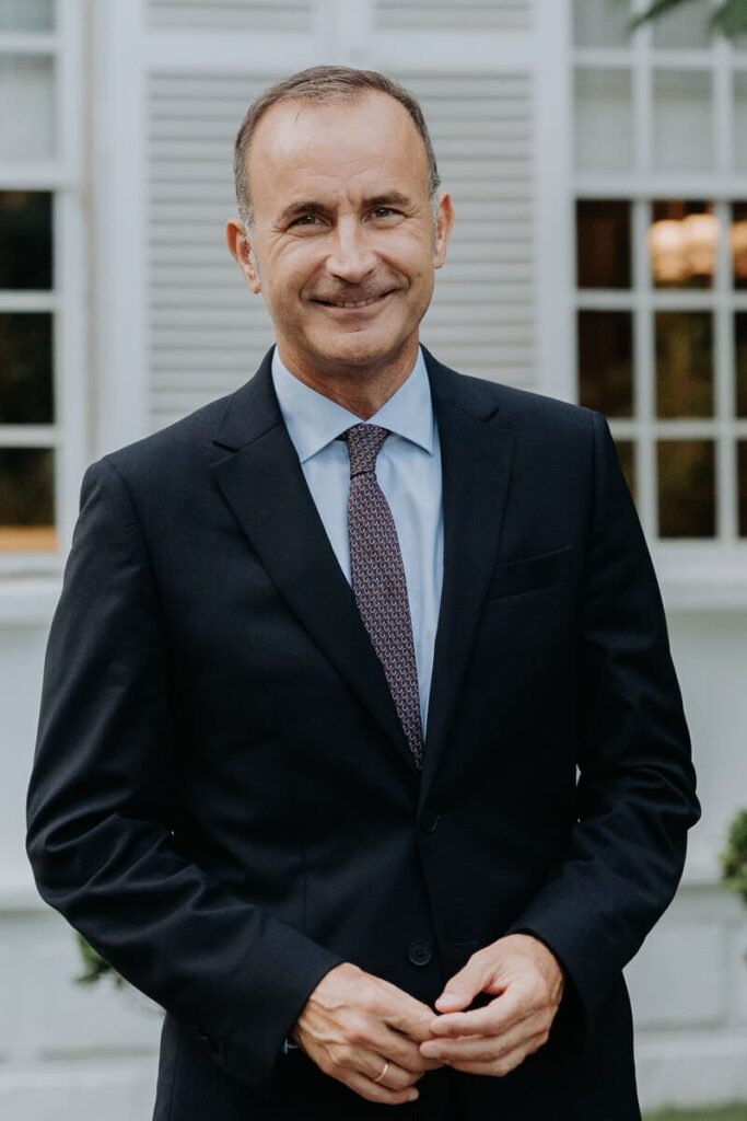 Foto de medio cuerpo de Francisco Torres del Castillo. Chaqueta azul marino. Camisa azul claro. Corbata rojo granate moteada. Amplia sonrisa. Pelo corto castaño.